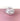 A white and pink vase on a pink surface with a white background