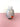 a colorful glass vase on a pink surface with a white background