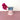 a pink and blue vase with flower on a pink surface with a white background