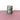 Purple and mint colored tumblers on a pink surface with a white background