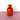 A red vase on a pink surface with a white background