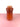 a red vase on a pink surface and white background
