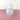 A translucent white vase on a pink surface on a white background